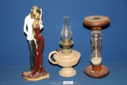 A resin figure of a couple, plus a wooden egg timer and a small china oil lamp.