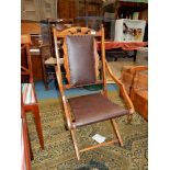 An unusual hardwood framed folding Armchair upholstered with dark brown simulated leather seat and