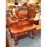 A Duchess type Mahogany Dressing Table, the oval mirror raised on supports with seven small drawers,