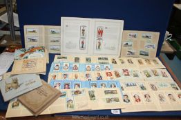 A box of cigarette cards in albums, themes to include cricketers, dogs, RAF badges etc.