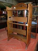 An Arts & Crafts floor standing Oak bookshelves having fretworked sides and top rail depicting