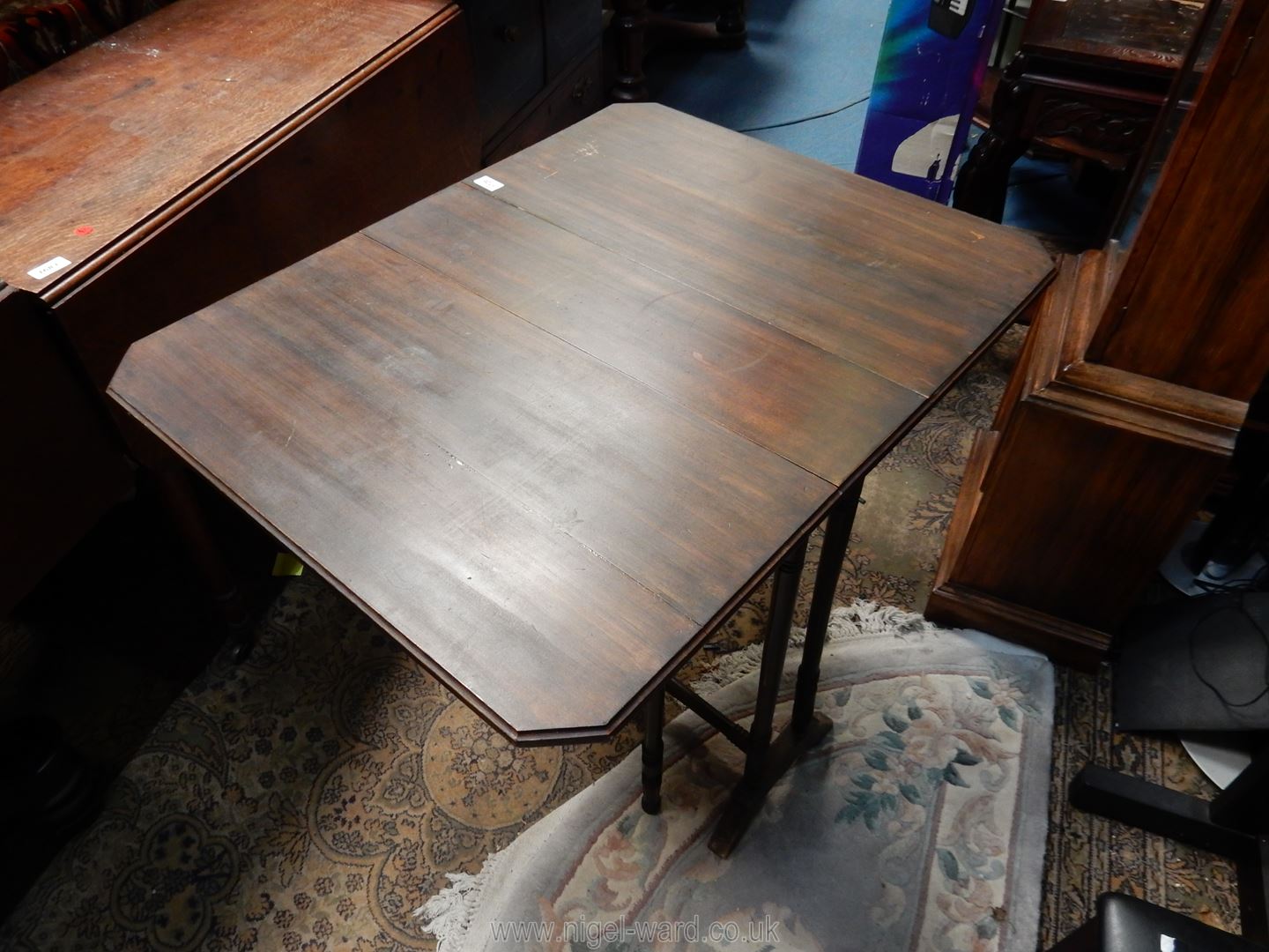 A circa 1900 dark Mahogany Sutherland Table standing on turned supports,