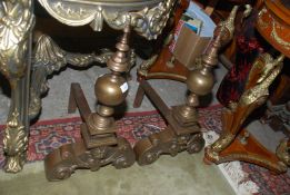A pair of very heavy brass and cast metal Fire Dogs with stylized satyr masks and scroll design,