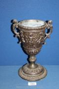 An attractive cast iron chalice style vase decorated with cherubs and Grecian designs,