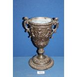 An attractive cast iron chalice style vase decorated with cherubs and Grecian designs,
