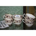 Six Derby teacups with berry and foliage decorated borders with gold highlights.