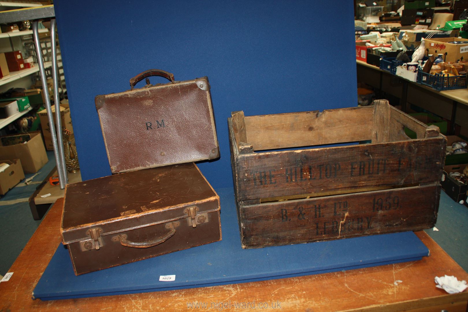 A wooden crate for The Hill Top Fruit Farm, Ledbury and two small suitcases.