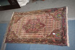 A small Turkish rug, multi-coloured, bordered, patterned and fringed, some wear to the edges,