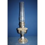A metal based Oil lamp with glass chimney, single burner, 23'' high overall.