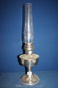 A metal based Oil lamp with glass chimney, single burner, 23'' high overall.