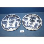 A pair of oriental blue/white plates depicting figures, 8 1/4'' diameter, one badly cracked.