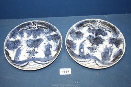 A pair of oriental blue/white plates depicting figures, 8 1/4'' diameter, one badly cracked.