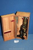 A small brass microscope in wooden case.
