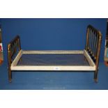 A Victorian dolls bed with brass ends, wooden frame and wire mesh base,