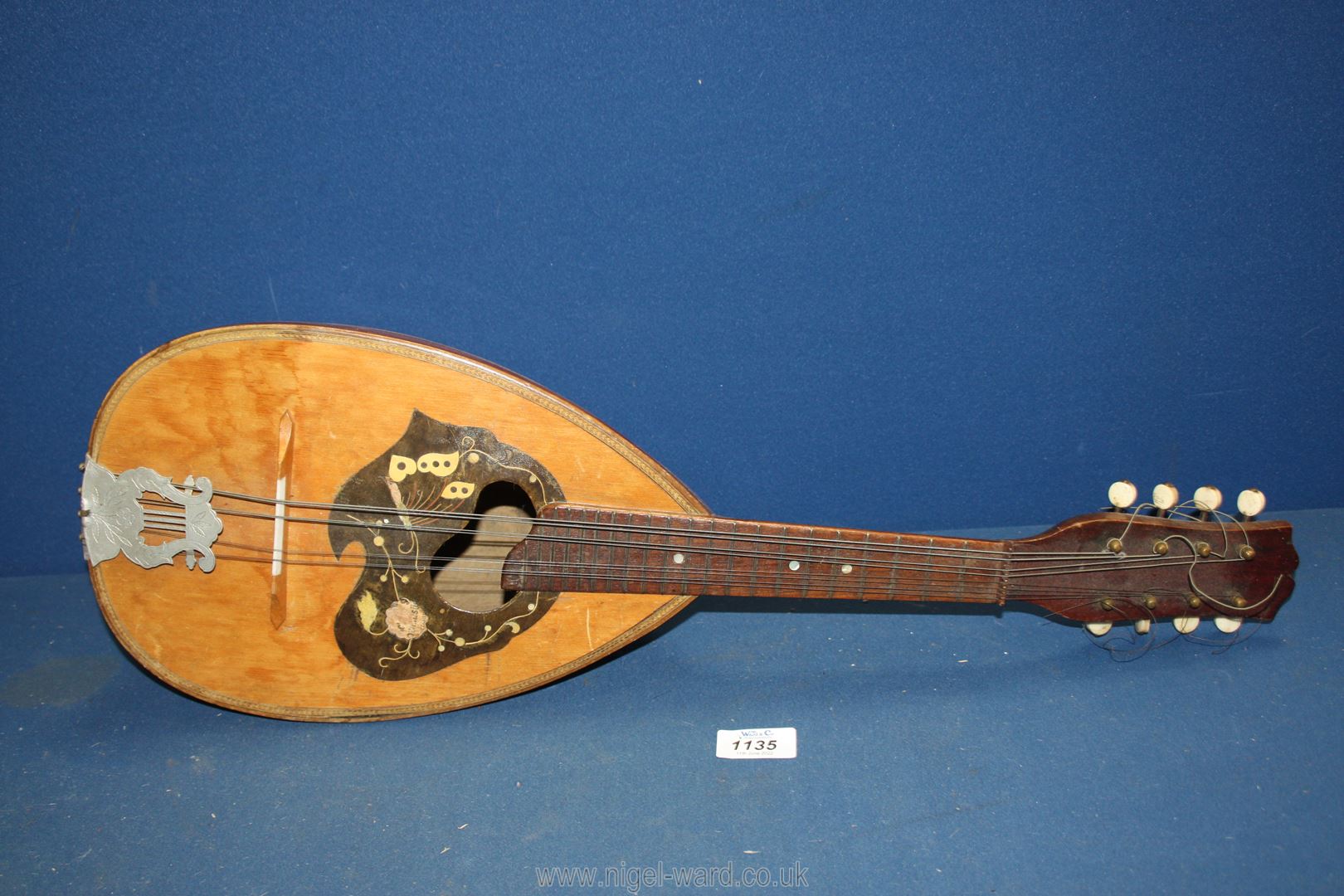 An old mandolin with butterfly shaped inlay (a/f) and Mother of pearl detail, some damage,