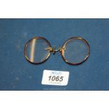 A cased pair of Tortoiseshell framed Pince-nez spectacles with spring nose clips.