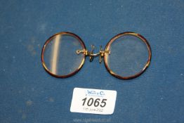 A cased pair of Tortoiseshell framed Pince-nez spectacles with spring nose clips.