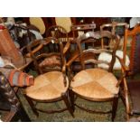 A pair of unusual seagrass seated open armed Carver Chairs having ladder backs and top rails with a