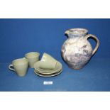 A jug and three coffee cups and saucers by Studio Pottery having Bernard Leach pottery marks.