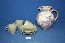 A jug and three coffee cups and saucers by Studio Pottery having Bernard Leach pottery marks.