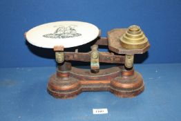 A vintage set of scales with ceramic top and set of weights.