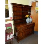 A Reproduction Oak Dresser with two drawers, two door cupboard below and having carved detail.