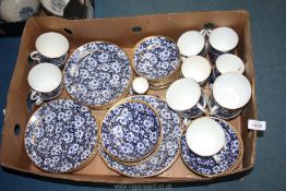 A good quantity of china in allover blue and white blossom design with gilt rim including,