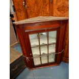 A circa 1900 Mahogany wall hanging corner Cabinet having a nine pane glazed door,