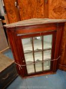 A circa 1900 Mahogany wall hanging corner Cabinet having a nine pane glazed door,
