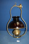 A ceiling fitting oil lamp converted to electric with brass reservoir and frame and dark red/purple