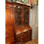 A circa 1900 Mahogany Bureau Bookcase having a pair of opposing 13 pane geometrically glazed doors