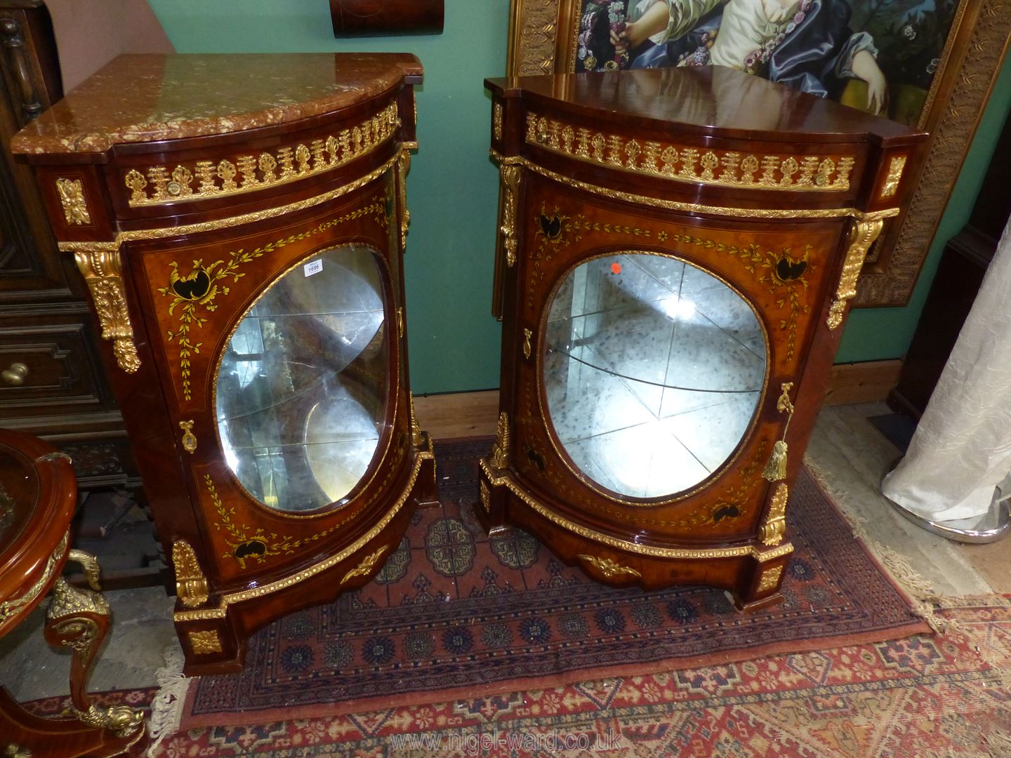 A pair of most ornate Corner Cabinets each having an upper frieze drawer and an oval panel glazed