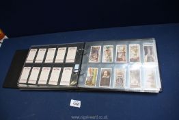 A blue album of Cigarette cards in plastic pages in full sets to include Ogden's, Carreras,