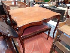A serpentine sided Mahogany Table standing on canted cabriole legs terminating on brass castors,