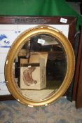 An oval gilt framed bevelled edge hanging Mirror, (some losses to frame) 21" x 16 1/2".
