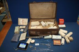 A small suitcase and contents of vintage bandages and First Aid items.