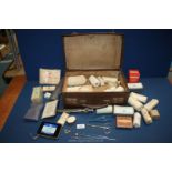 A small suitcase and contents of vintage bandages and First Aid items.