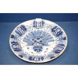 A large Delft earthenware dish, some chips to rim, 13 3/4" diameter.