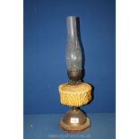 A wood and metal based Oil Lamp with yellow reservoir, 21'' tall overall.