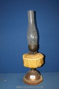 A wood and metal based Oil Lamp with yellow reservoir, 21'' tall overall.