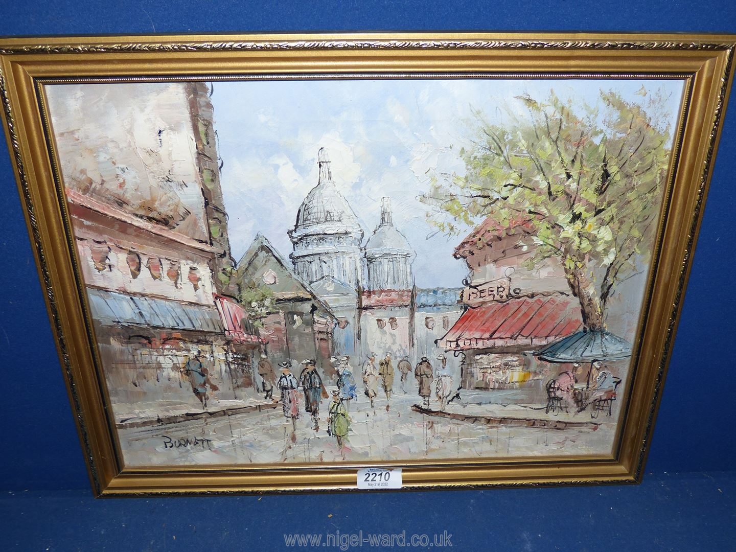 A framed oil on canvas depicting a street scene, signed lower left 'Burnett'.
