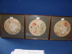 Three framed circular mounted oriental prints on fabric of flowers and butterflies,