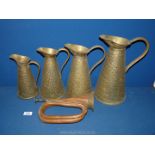 A bugle and graduated set of four brass measuring jugs.