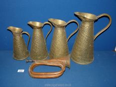 A bugle and graduated set of four brass measuring jugs.