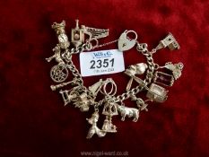 A silver Charm bracelet with charms to include church, tv, clock, cow, rabbit, etc.