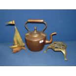 A copper kettle, brass trivet and a brass model of a sailing boat.