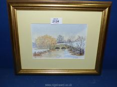 A framed and mounted Watercolour depicting a Winter landscape with stone bridge and river,