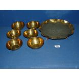 An Arts and Crafts style brass Tazza and six small engraved Islamic brass bowls.