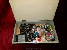 A wooden box of costume jewellery including bracelets, beads, brooches etc.