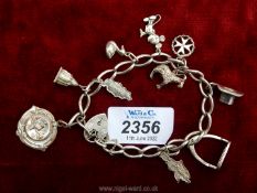 A silver Charm bracelet, plus charms to include medal 1952, London silver locket 1978, Mickey Mouse,